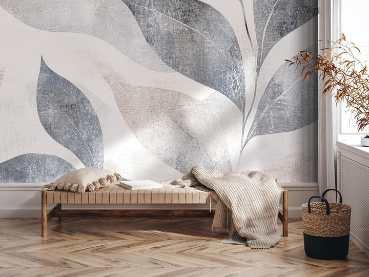 a modern and minimalist interior design with a large abstract leaf-like mural on the wall behind a wooden bench. The bench is adorned with a blanket and a basket, creating a cozy and inviting atmosphere.