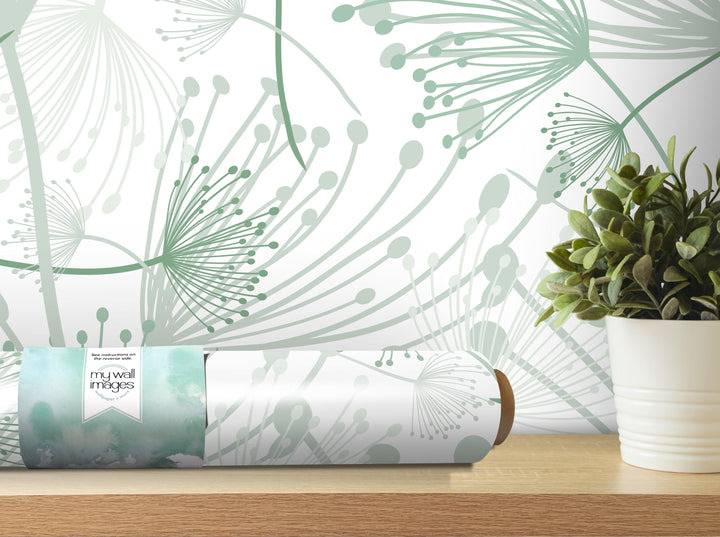 a wallpapered wall with a green and white abstract design, a potted plant, and a roll of wallpaper on a shelf.