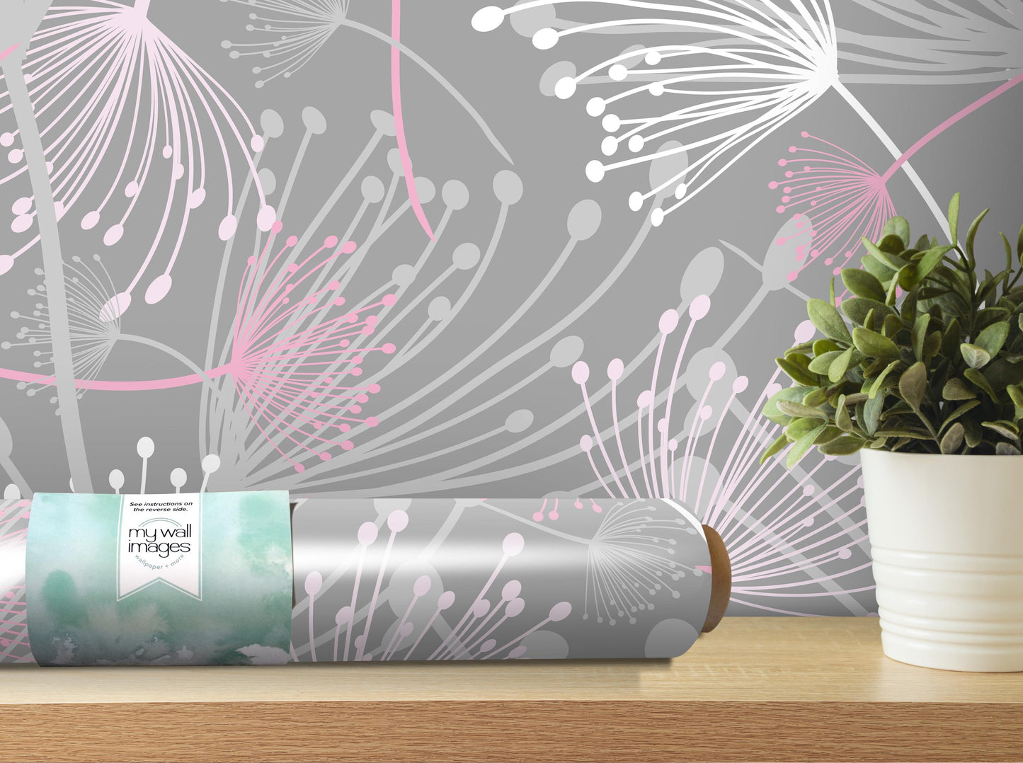 a gray wall with a floral pattern and a white vase with a green plant on a wooden shelf.