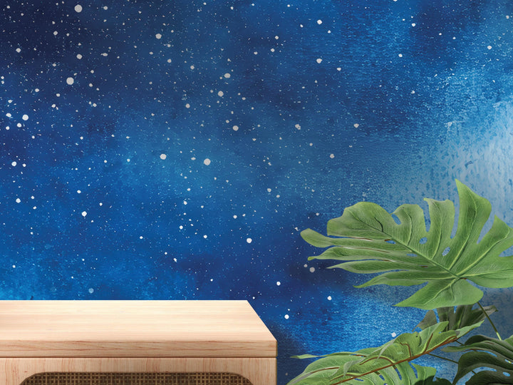 a wooden table against a starry night sky background, with a large green leaf in the foreground.