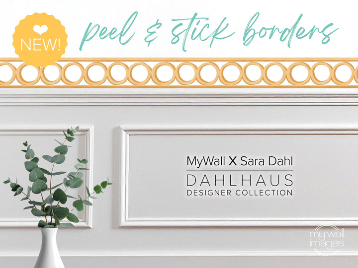 a white wall with a vase of green leaves, and there is text that reads &quot;MyWall X Sara Dahl Dahlhaus Designer Collection&quot;.