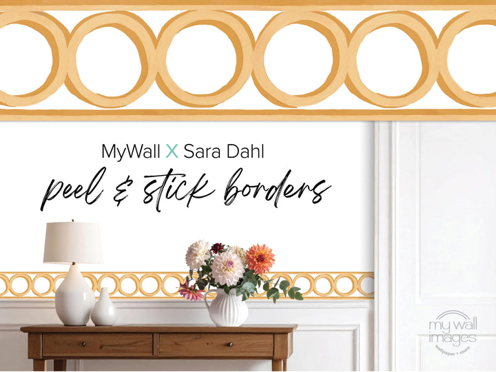 a wooden table with a vase of flowers, a lamp, and a decorative border along the wall.